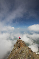 Hochformatige Ansicht von Freunden, die auf dem Cheam Peak inmitten von Wolken stehen - CAVF30910