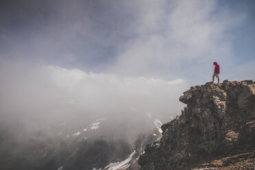 Seitenansicht eines Wanderers, der auf einer Klippe vor einem bewölkten Himmel steht - CAVF30916