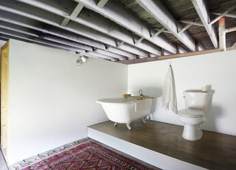 Bathtub by toilet bowl in bathroom - CAVF30933