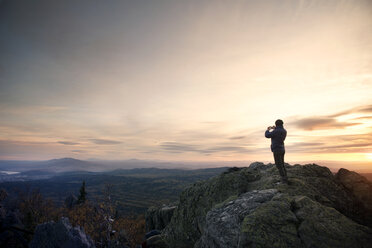 Woman standing on mountain during sunset - CAVF31084