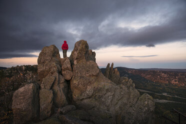 Wanderin steht auf einem Berg vor bewölktem Himmel - CAVF31085