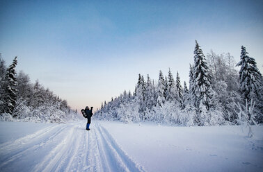 Hiker standing on snow covered field against sky - CAVF31094