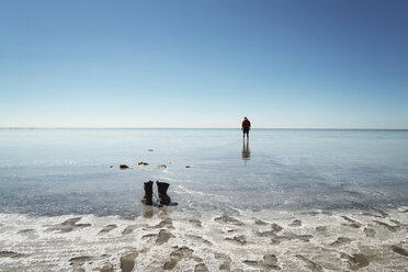 Mittlere Entfernung eines am Strand stehenden Mannes gegen den Himmel - CAVF31116