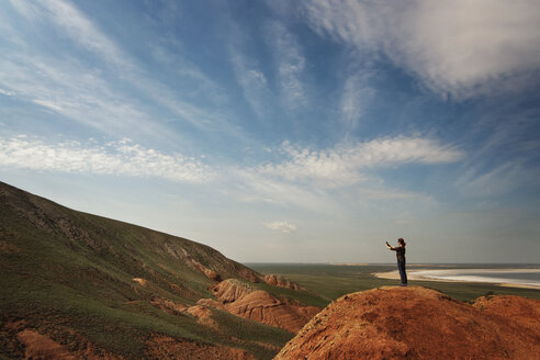Seitenansicht einer Frau, die auf einem Berg stehend gegen den Himmel fotografiert - CAVF31119