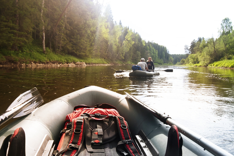 Couple traveling on inflatable boat in river during summer stock photo
