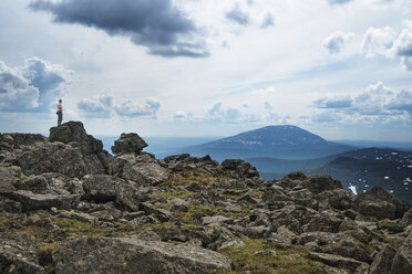 Man standing on rock at mountain against sky - CAVF31147