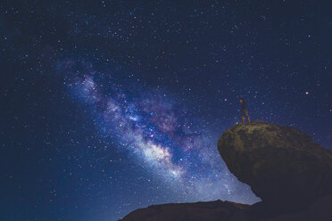 Man standing on rock in Joshua Tree National Park and looking at Milky Way - FOLF03633