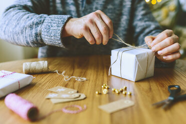 Mann wickelt Weihnachtsgeschenke ein - FOLF03642