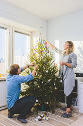 Ehepaar schmückt gemeinsam den Weihnachtsbaum - FOLF03647