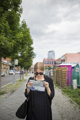 Young woman in Berlin with city map - FOLF03667