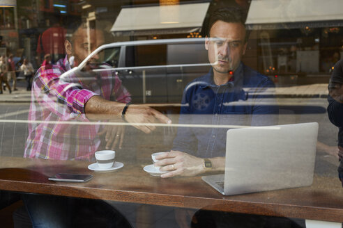 Reife Männer schauen auf den Laptop im Cafe - FOLF03708