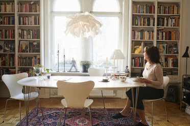 Woman sitting alone at table - FOLF03728