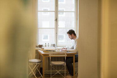 Man using laptop at table - FOLF03819