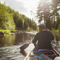 Mann paddelt mit Kanu den Fluss entlang - FOLF03886