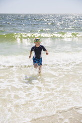 Kleiner Junge mit Tauchermaske läuft gegen das Meer - FOLF03904