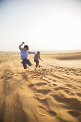 Zwei Jungen springen auf Sand in der Wüste - FOLF03909