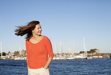 Portrait of smiling young woman with sea in background - FOLF03933