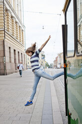 Young woman jumping out of tram - FOLF03937