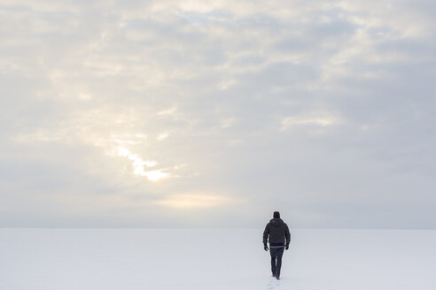 Rückansicht eines reifen Mannes, der auf Schnee läuft - FOLF03986
