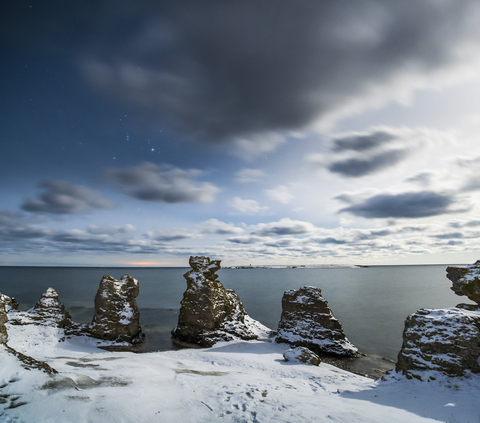 Felsformationen im Schnee an der Küste, lizenzfreies Stockfoto