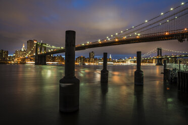 Beleuchtete Brücke und Wolkenkratzer in New York City bei Sonnenuntergang - FOLF04077