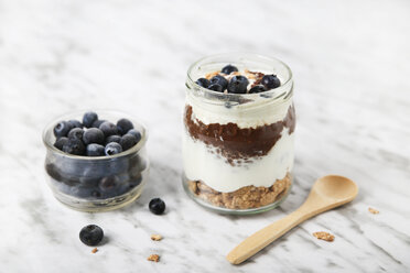 Ein Glas Chia-Pudding-Parfait mit Schokolade und Joghurt mit Blaubeeren und Granola - RTBF01117