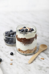 Ein Glas Chia-Pudding-Parfait mit Schokolade und Joghurt mit Blaubeeren und Granola - RTBF01118