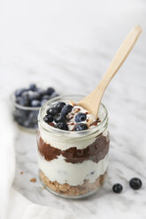 Ein Glas Chia-Pudding-Parfait mit Schokolade und Joghurt mit Blaubeeren und Granola - RTBF01119