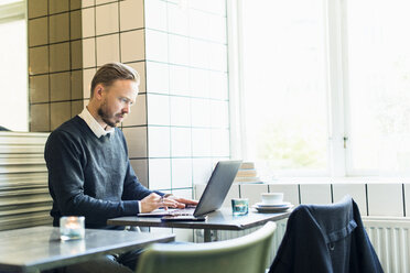 Geschäftsmann arbeitet an einem Laptop in einem Cafe - FOLF04083