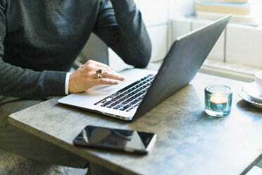 Geschäftsmann arbeitet an einem Laptop in einem Cafe - FOLF04084