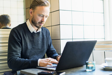 Businessman working on laptop in cafe - FOLF04085