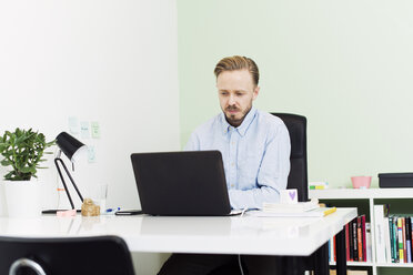 Geschäftsmann arbeitet am Laptop im Büro - FOLF04088