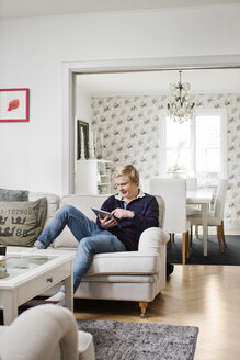 Jugendlicher mit Tablet-PC auf dem Sofa - FOLF04101