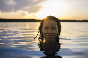 Porträt einer jungen Frau beim Schwimmen im See an einem sonnigen Tag - FOLF04243