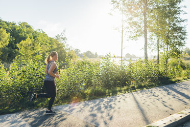 Junge Frau joggt auf dem Bürgersteig - FOLF04292