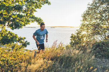 Mittlerer Erwachsener Mann beim Joggen am Meeresufer - FOLF04294