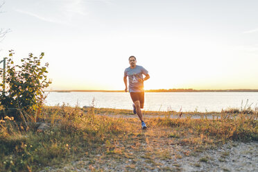 Mittlerer Erwachsener Mann beim Joggen am Meeresufer - FOLF04296