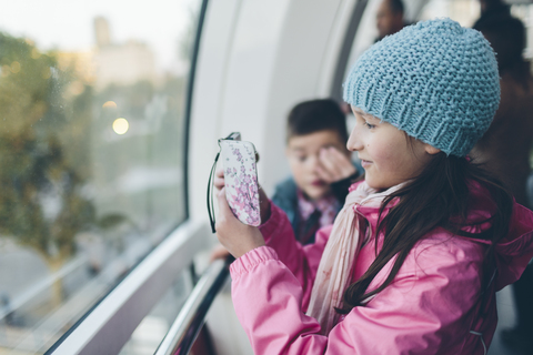 Mädchen fotografiert mit Smartphone und Junge im London Eye, lizenzfreies Stockfoto