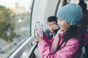 Mädchen fotografiert mit Smartphone und Junge im London Eye - FOLF04311