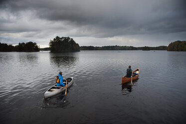 Mann paddelt mit Kanu auf einem See - FOLF04330