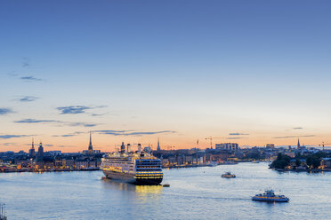 Beleuchtetes Hafenviertel in Stockholm bei Sonnenuntergang mit vorbeifahrender Fähre und Schiffen - FOLF04391