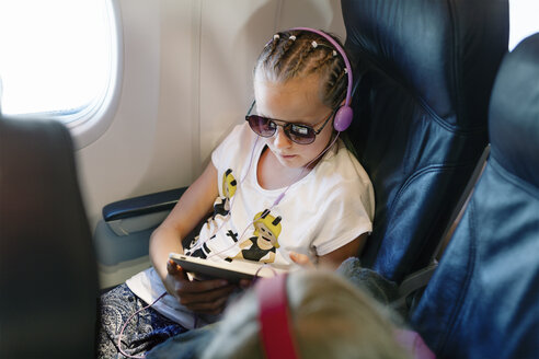 Mädchen hält ein Tablet in einem Flugzeug - FOLF04655