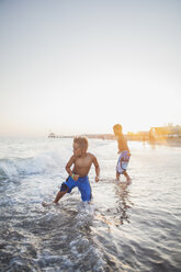 Kinder spielen in der Brandung an einem Strand - FOLF04750