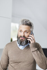 Man in a brown sweater talking on a cell phone - FOLF04765