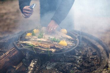 Mann kocht auf einem Lagerfeuer - FOLF04777