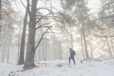 Man walking through a snowy forest - FOLF04788