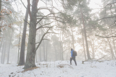 Mann geht durch einen verschneiten Wald - FOLF04788