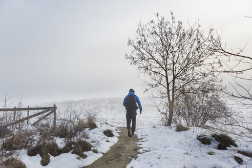 Mann geht auf einem verschneiten Weg - FOLF04790