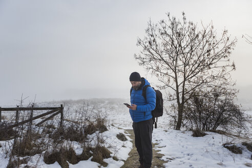 Mann geht auf einem verschneiten Weg - FOLF04791