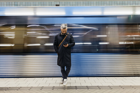 Man texting at train station - FOLF04856